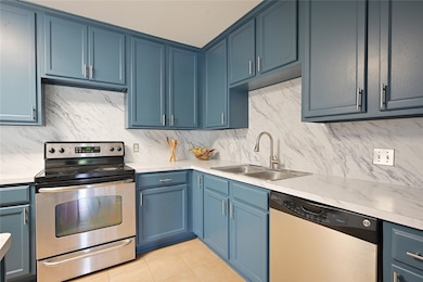 Kitchen with a sink, decorative backsplash, applia