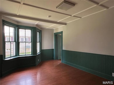 Spare room featuring dark wood-style floors, wainscoting, beamed ceiling, cooling unit, and coffered ceiling
