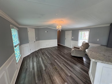 Unfurnished room featuring a chandelier, dark wood