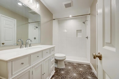 Bathroom featuring vanity, a shower stall, dark tile patterned floors, and recessed lighting