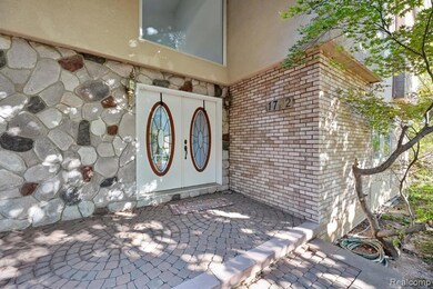 Doorway to property with brick siding, stucco siding, and a patio