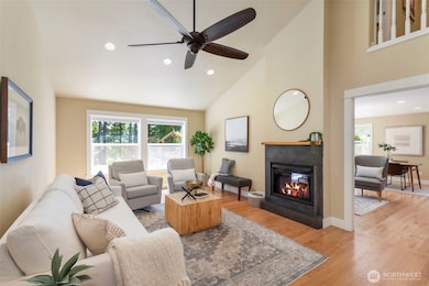 The light-filled living room features expansive windows and cozy fireplace for style and function.