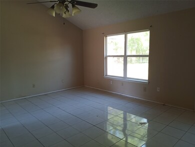 FAMILY ROOM WITH CEILING FAN ON WOOD BEAM AND WINDOWS TO BACK YARD.