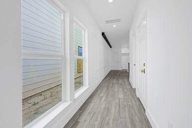 Bright hallway lined with tall windows and elegant