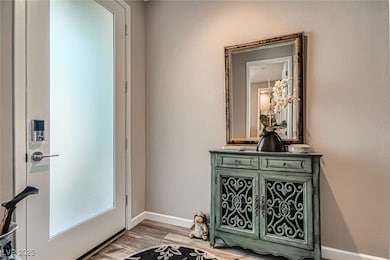 Entrance foyer featuring baseboards and light wood