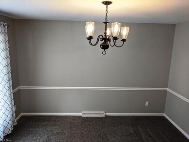 The dining room has new carpet and a large window 