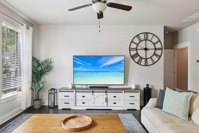 Living area featuring dark wood-style flooring and ceiling fan