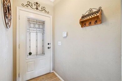 Doorway to outside featuring baseboards and light 