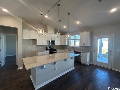 Kitchen featuring lofted ceiling, white cabinets, 
