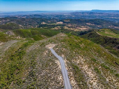 Aerial shot of building site at the end of the road. gentle slopes and views all around.