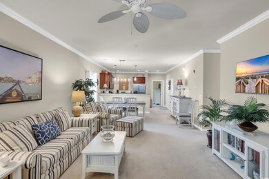 Living area with light carpet, ceiling fan, and ornamental molding