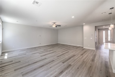 Unfurnished room featuring light wood-type flooring, a ceiling fan, and recessed lighting