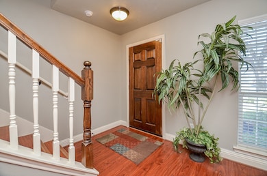 Enter your new home through the solid wood door into the entry with plank wood flooring that is cohesive throughout the home.