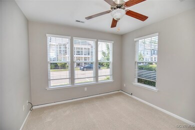 Carpeted spare room featuring ceiling fan and a he