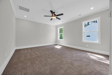Unfurnished room with dark colored carpet, baseboards, ceiling fan, recessed lighting, and ornamental molding