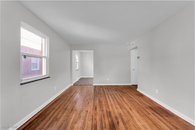 Unfurnished room with hardwood / wood-style floors and baseboards