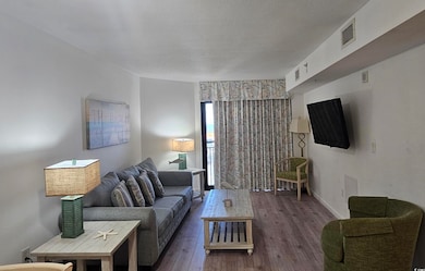 Living room featuring hardwood / wood-style flooring and a textured ceiling
