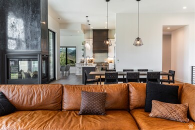 Living area featuring light wood-style floors, a multi sided fireplace, and recessed lighting