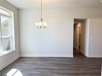Unfurnished dining area featuring healthy amount of natural light, dark wood finished floors, and a chandelier