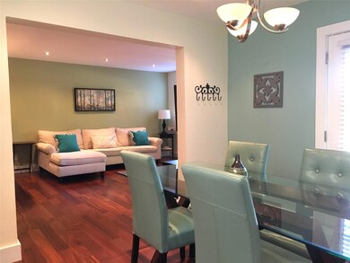 Dining space with dark wood-type flooring, an inv