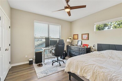 Bedroom with baseboards, wood finished floors, mul