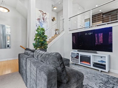 Living area with carpet floors, stairs, and a glass covered fireplace