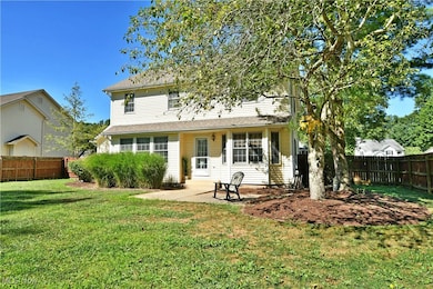 Rear view of house with a fenced backyard and a patio area