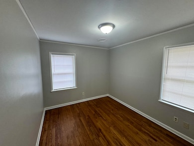 Unfurnished room featuring crown molding and dark hardwood / wood-style flooring