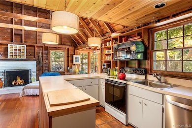 Kitchen with electric stove, vaulted ceiling, dishwasher, wooden ceiling, and black microwave
