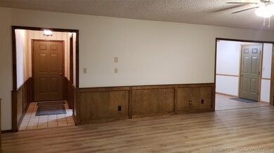 Living room towards front door on left and door to