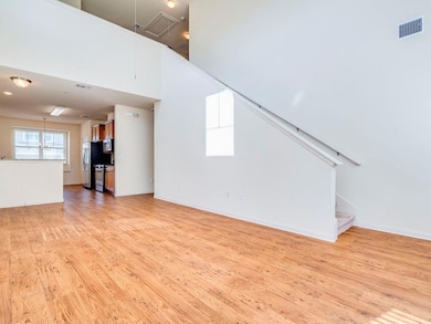 Unfurnished living room featuring attic access, l
