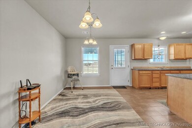 Kitchen with light brown cabinetry, pendant lighti