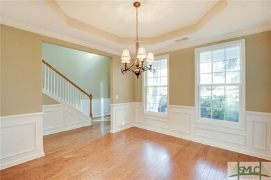 Separate dining room with tray ceiling, wainscotin