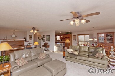 The living room also features two ceiling fans.