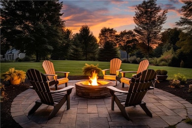 Patio terrace at dusk featuring a lawn and a fire 