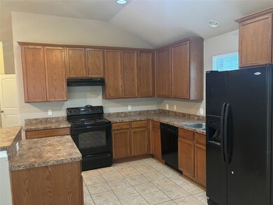 Kitchen featuring black appliances, sink, light tile patterned floors, and vaulted ceiling