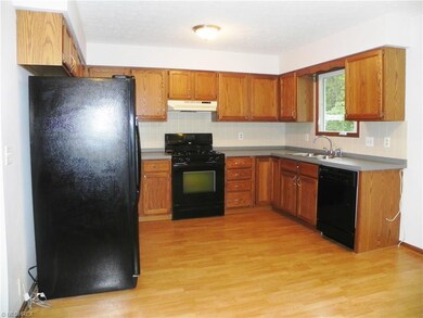 Spacious kitchen with newer laminated flooring.