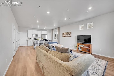 Living room with sink and light wood-type flooring