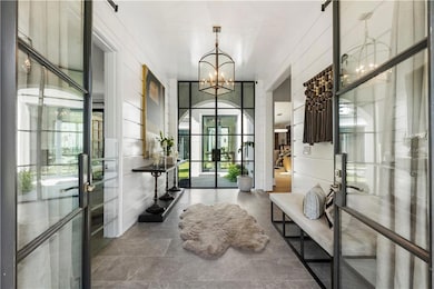 Wide framed double iron doors open to grand foyer 