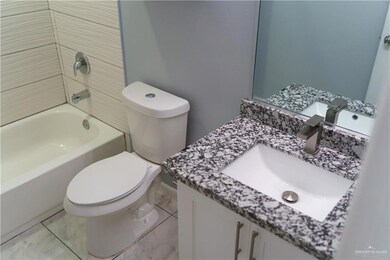 Full bath featuring vanity, washtub / shower combination, and marble finish floors