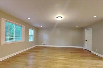 Empty room with light wood finished floors and recessed lighting