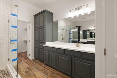 Bathroom featuring a shower stall, vanity, and wood finished floors