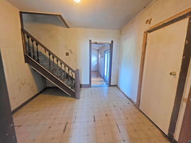 Foyer with light flooring and stairway