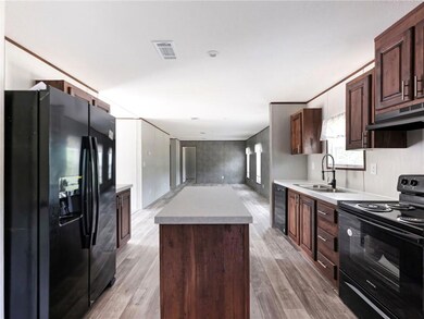Kitchen with black appliances, a sink, under cabin