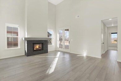 Unfurnished living room with light hardwood / wood-style floors and a high ceiling