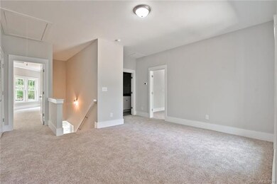 Another view of the bonus room! Extra wide pull down attic stairs for access to HVAC system.