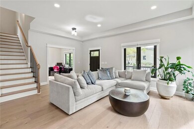 Living room featuring stairs, light wood-type flooring, healthy amount of natural light, and recessed lighting