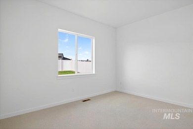 Carpeted spare room with baseboards