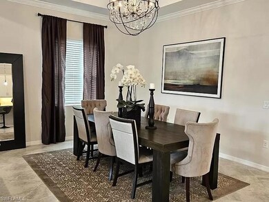 Tiled dining space featuring ornamental molding and a chandelier