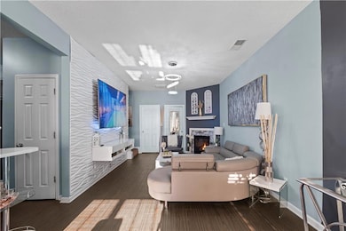 Living room with baseboards, a textured ceiling, v